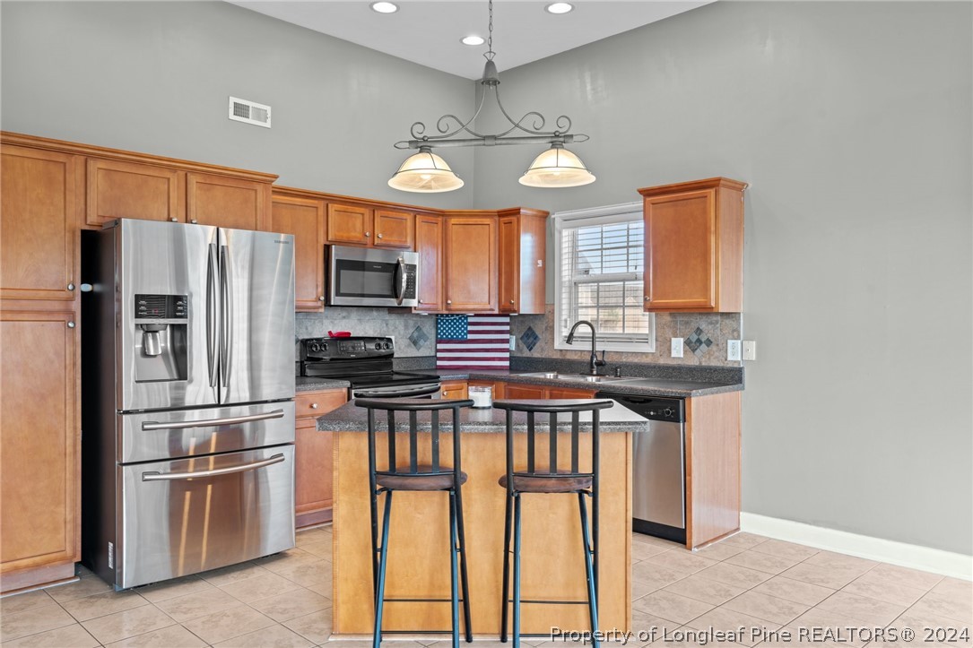 176 Clearbrook Place Raeford, NC 28376 - Photo 13 of 36 a kitchen with stainless steel appliances granite countertop a refrigerator a stove and a sink