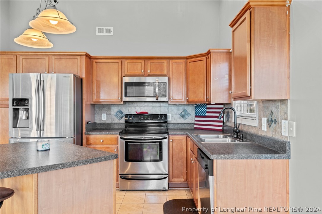 176 Clearbrook Place Raeford, NC 28376 - Photo 14 of 36 a kitchen with stainless steel appliances granite countertop a sink a stove and a refrigerator
