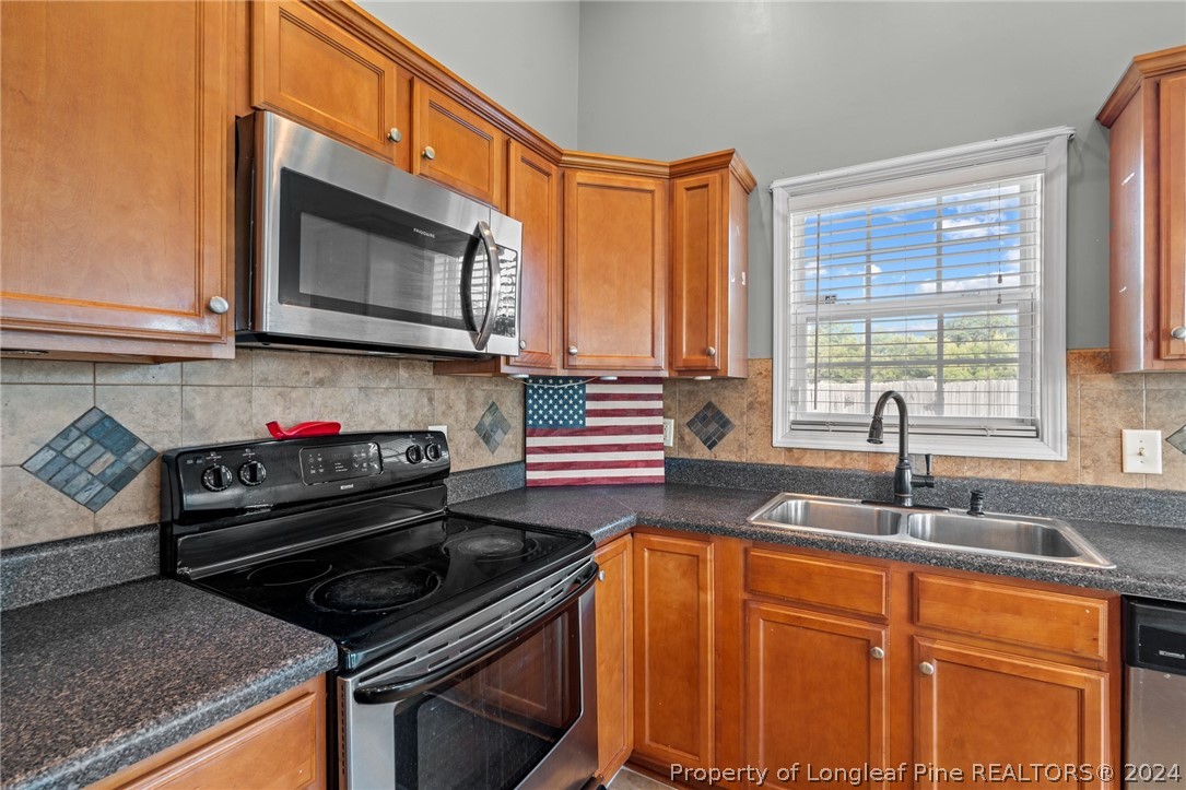 176 Clearbrook Place Raeford, NC 28376 - Photo 16 of 36 a kitchen with stainless steel appliances granite countertop a sink stove and microwave
