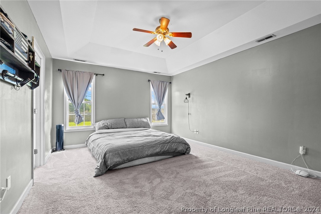176 Clearbrook Place Raeford, NC 28376 - Photo 23 of 36 a spacious bedroom with a bed and a chandelier