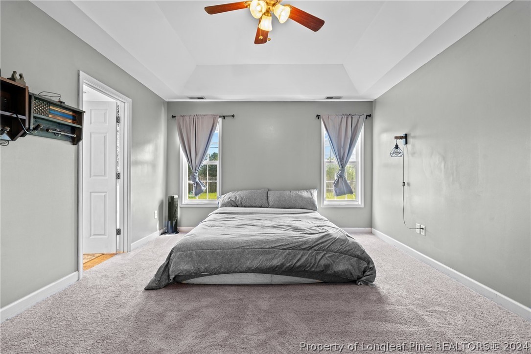 176 Clearbrook Place Raeford, NC 28376 - Photo 24 of 36 a bedroom with a bed closet and a chandelier