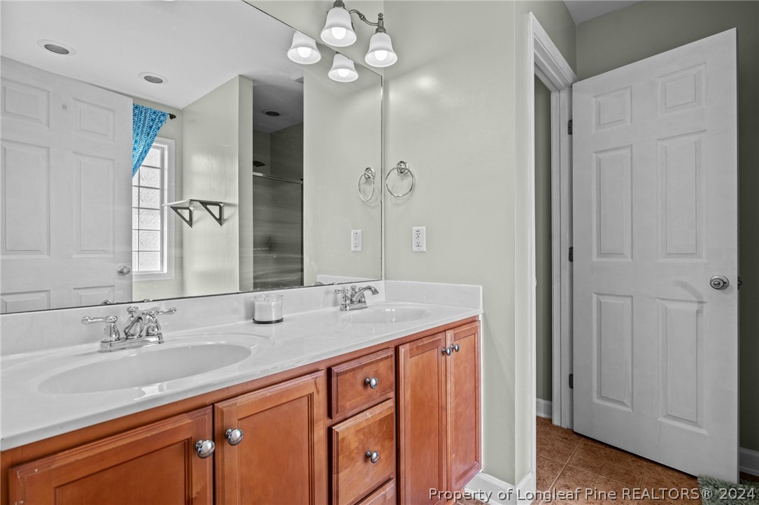176 Clearbrook Place Raeford, NC 28376 - Photo 27 of 36 a bathroom with a granite countertop sink a large mirror and a shower