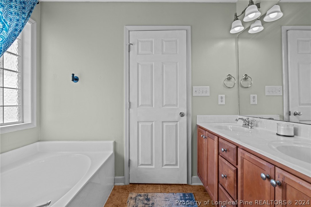176 Clearbrook Place Raeford, NC 28376 - Photo 28 of 36 a bathroom with a tub sink and mirror