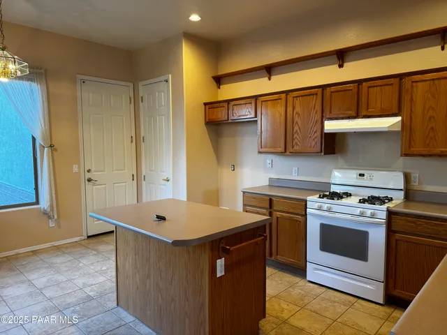 a kitchen with stainless steel appliances a white stove top oven cabinets a refrigerator and a sink