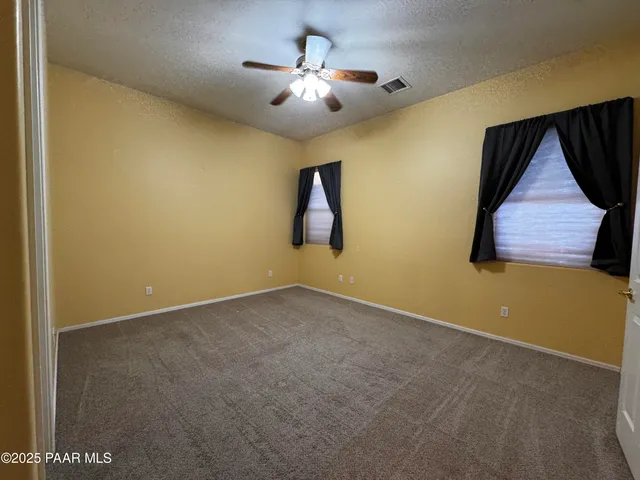 a view of empty room with ceiling fan