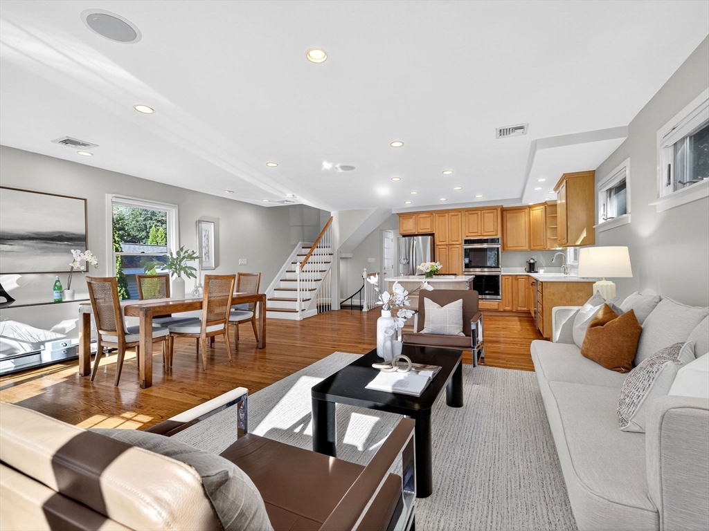 a living room with furniture kitchen view and a large window