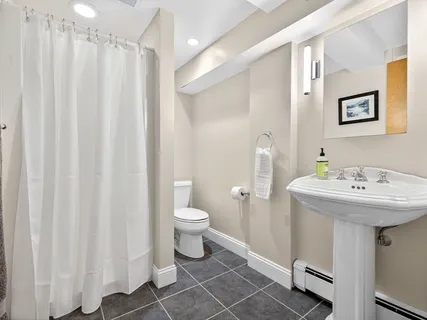 a bathroom with a sink a toilet and shower curtain