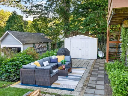 a view of house with a yard and sitting area