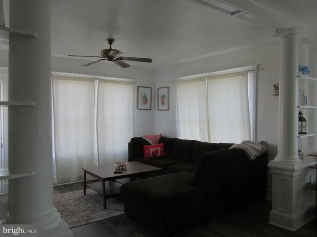 a living room with furniture and a ceiling fan