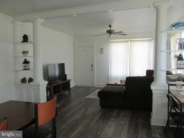a living room with furniture a ceiling fan and a window
