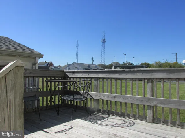 a view of a balcony with wooden floor and outdoor seating