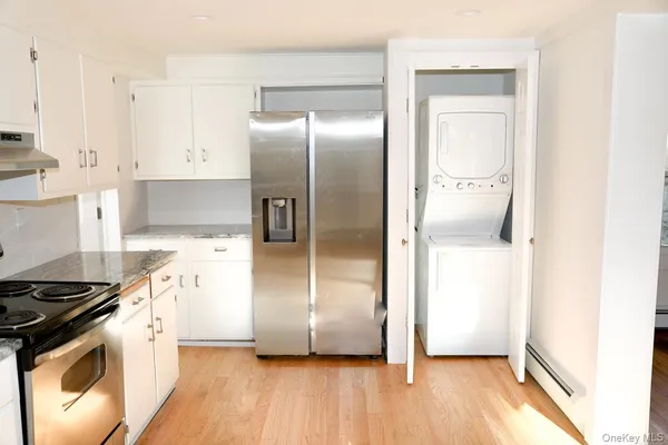 a kitchen with granite countertop a refrigerator and a stove top oven