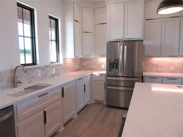 a bathroom with a double vanity sink mirror and bathtub