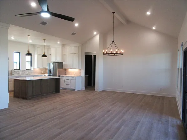 a kitchen with stainless steel appliances granite countertop a refrigerator a sink and a stove