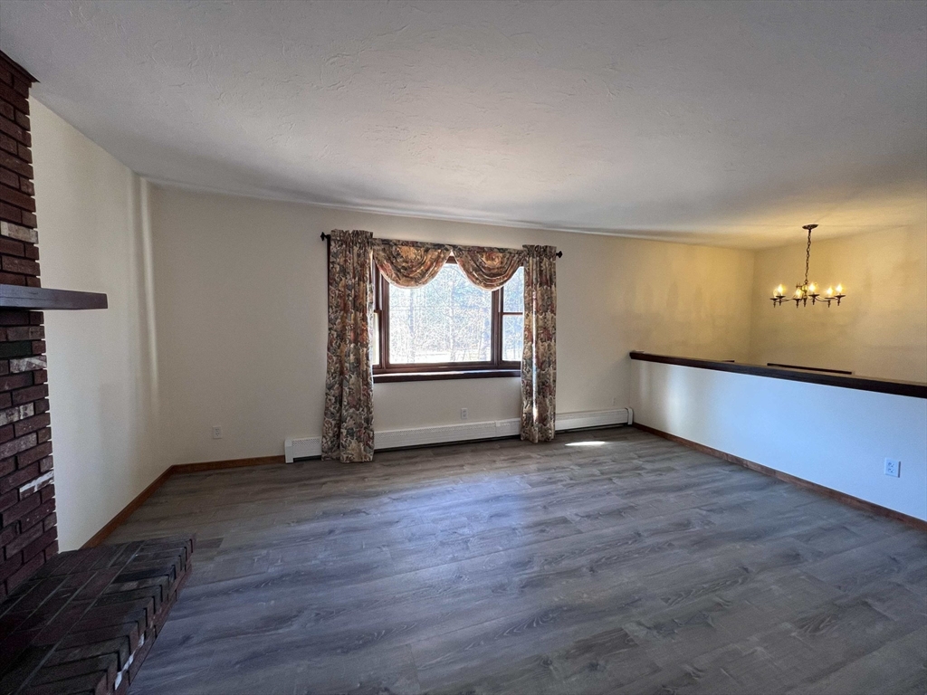 23 Hospital Road Templeton, MA 01436 - Photo 5 of 32 an empty room with wooden floor and windows