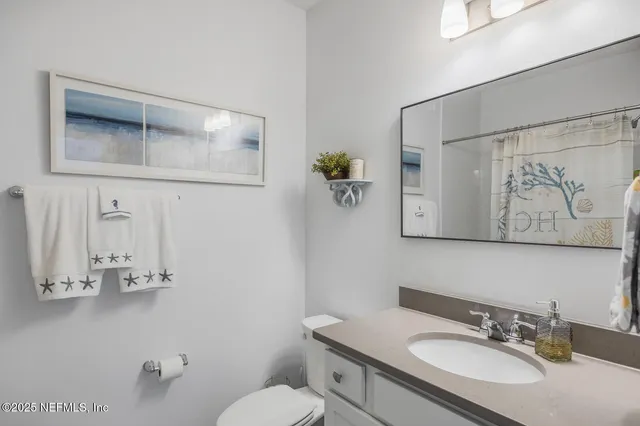 a bathroom with a granite countertop sink mirror and toilet