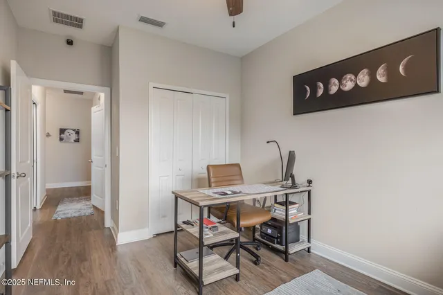 a view of a workspace with furniture and wooden floor
