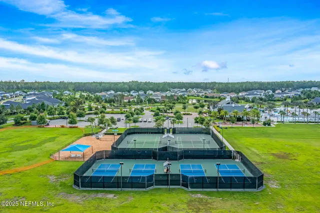 a view of a swimming pool with lawn chairs and a big yard