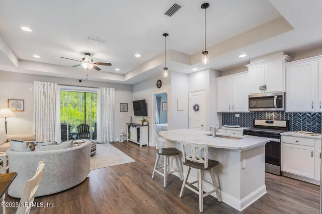 a large kitchen with a table chairs refrigerator and cabinets