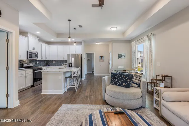 a living room with furniture and kitchen view