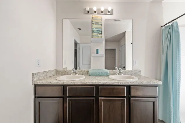 a bathroom with a granite countertop sink mirror and double