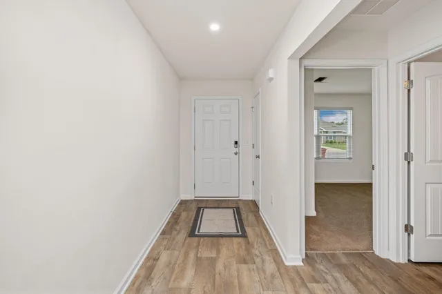 a view of a hallway with wooden floor and staircase