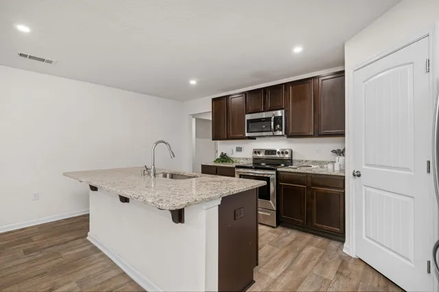 a kitchen with stainless steel appliances granite countertop a stove top oven a sink and dishwasher