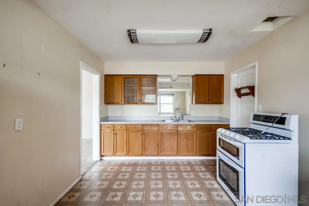 6316 Streamview Drive San Diego, CA 92115 - Photo 14 of 52 a kitchen with granite countertop a stove top oven sink and cabinets