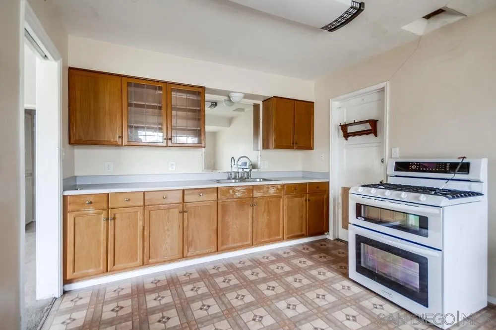 6316 Streamview Drive San Diego, CA 92115 - Photo 15 of 52 a kitchen with stainless steel appliances granite countertop a stove a sink and a microwave