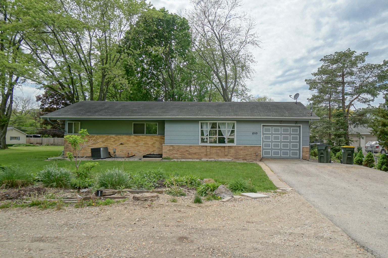 1010 North Elmhurst Road Prospect Heights, IL 60070 - Photo 1 of 15 a front view of a house with a garden and trees