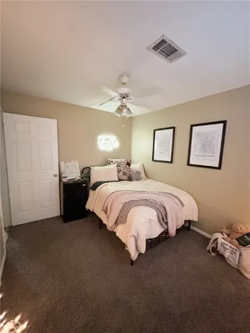 a spacious bedroom with a bed and a ceiling fan