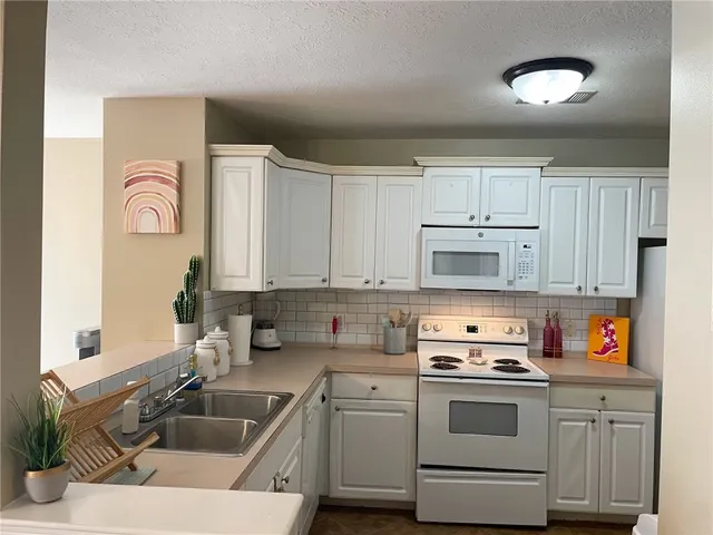 a kitchen with stainless steel appliances granite countertop a sink stove and cabinets