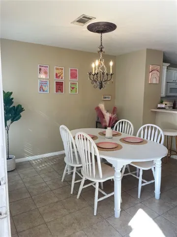 a view of a dining room with furniture a chandelier and wooden floor