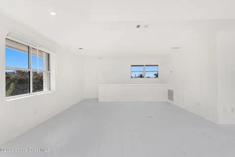 a view of an empty room with window and fireplace