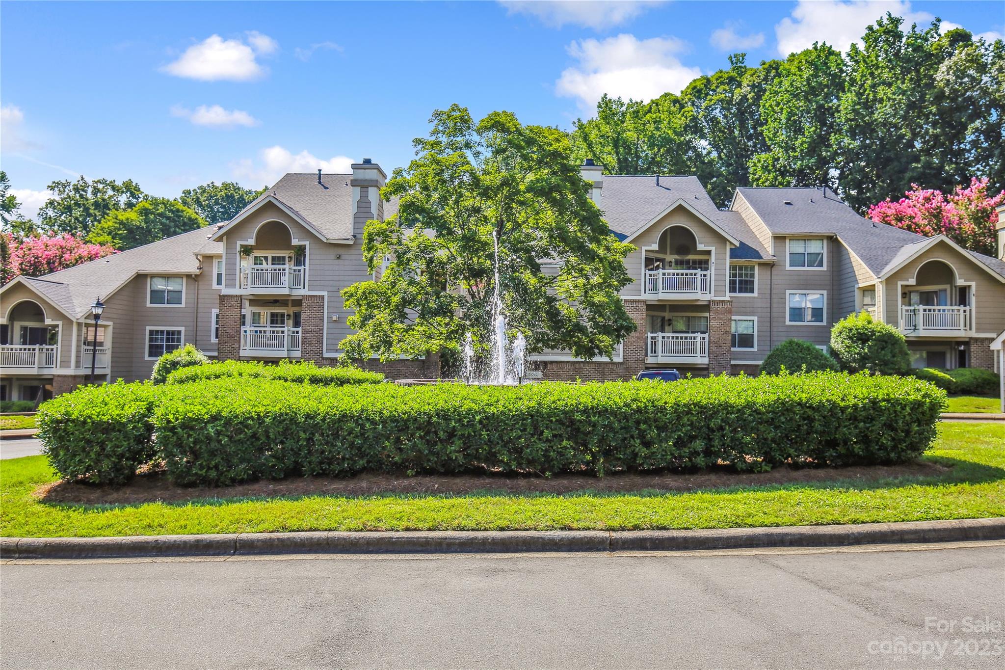 5007 Sharon Road, Unit E Charlotte, NC 28210 - Photo 1 of 30 a front view of a house with a yard and potted plants
