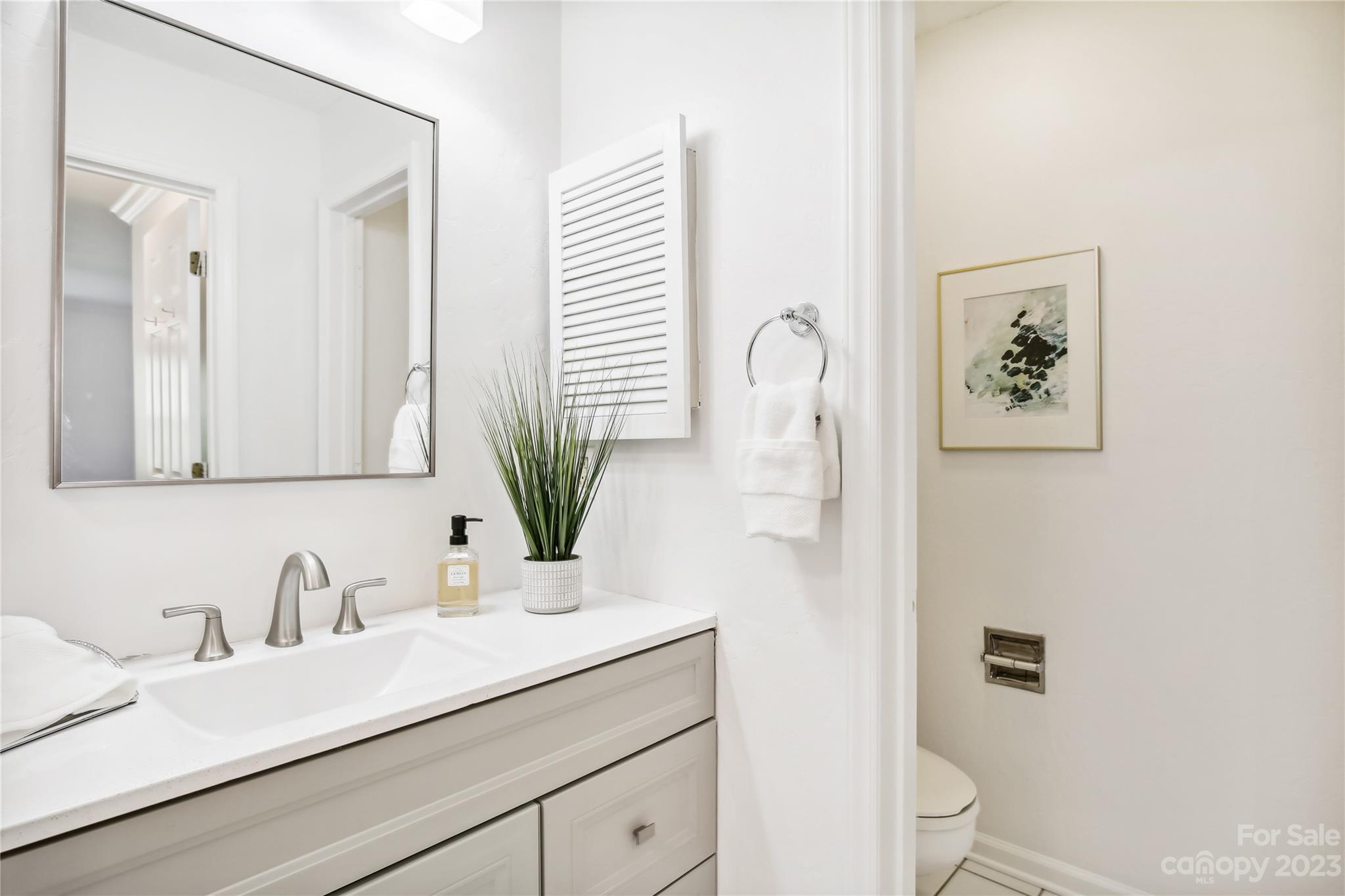 5007 Sharon Road, Unit E Charlotte, NC 28210 - Photo 20 of 30 a bathroom with a sink a toilet and mirror