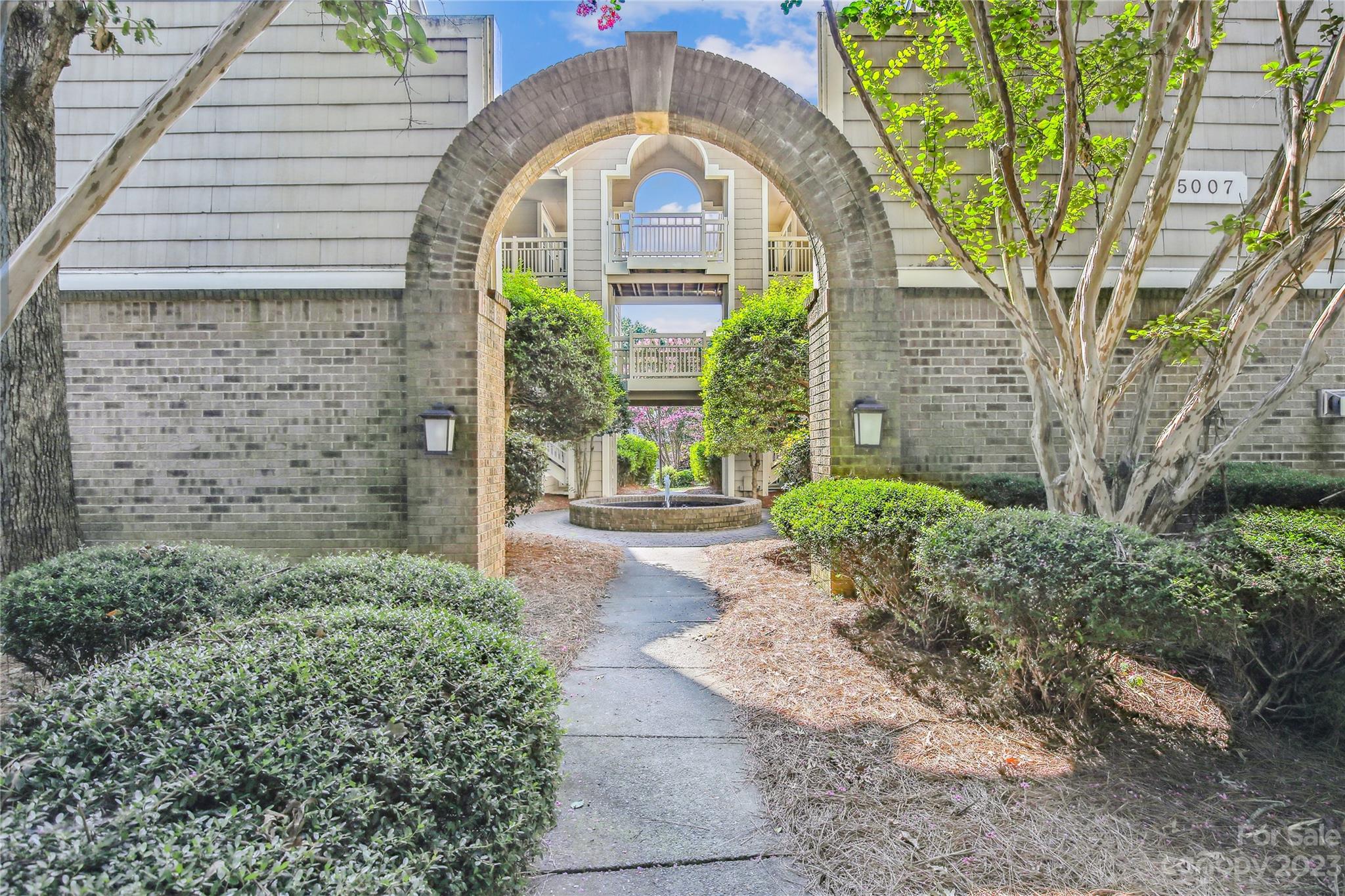 5007 Sharon Road, Unit E Charlotte, NC 28210 - Photo 2 of 30 a front view of a house with garden