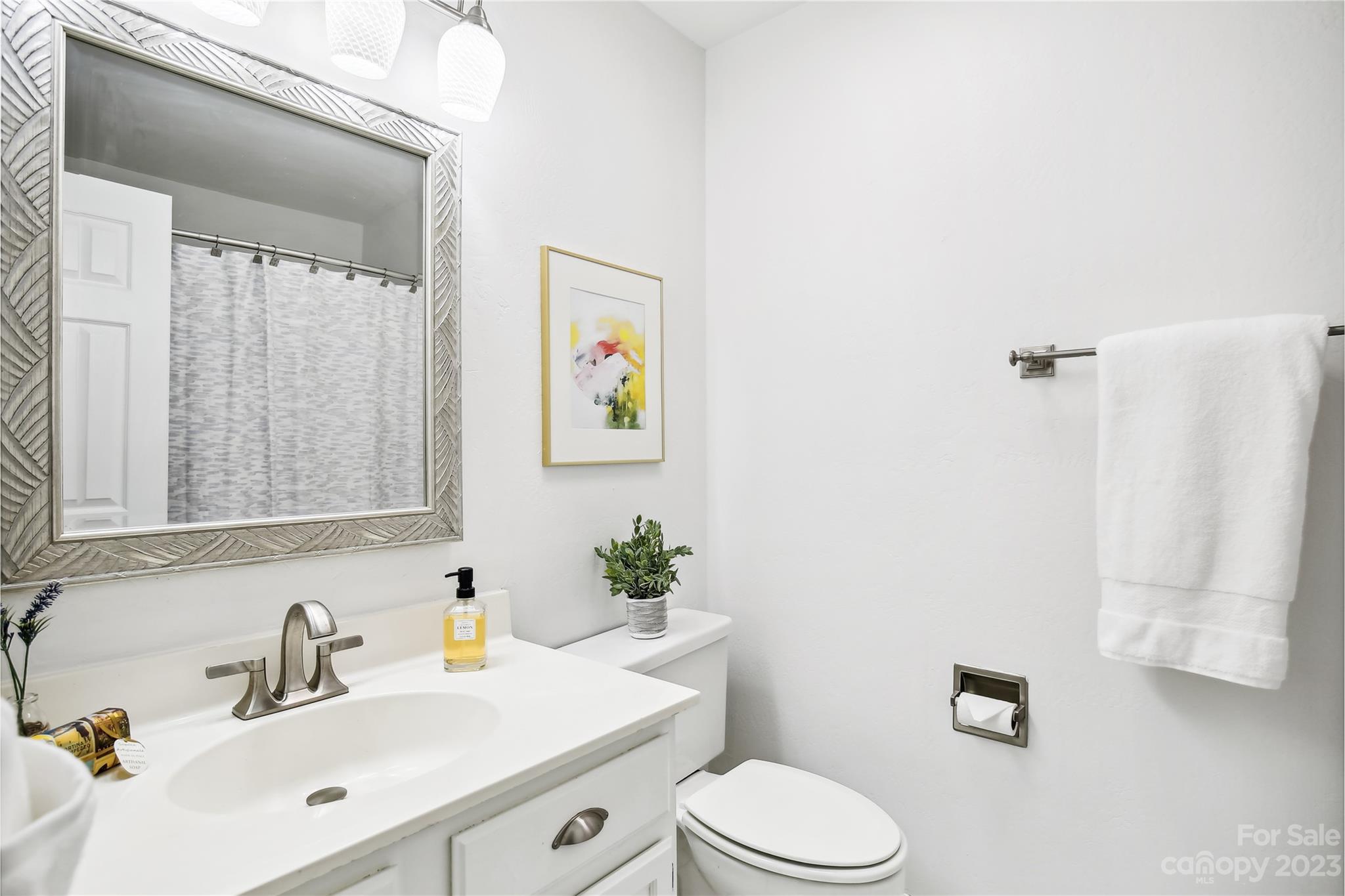 5007 Sharon Road, Unit E Charlotte, NC 28210 - Photo 24 of 30 a bathroom with a sink mirror and toilet