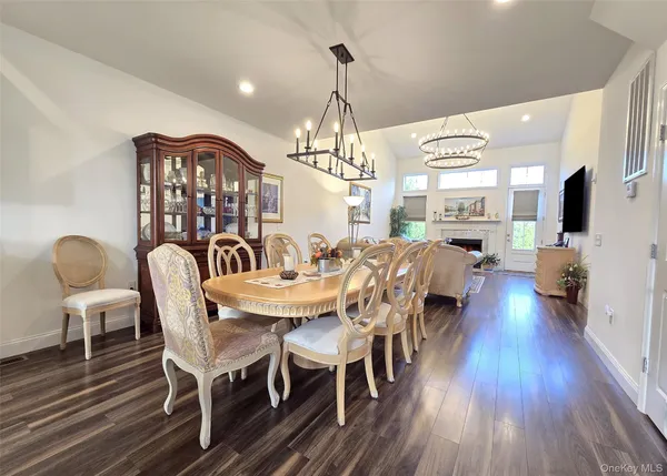 a kitchen with stainless steel appliances a dining table chairs refrigerator sink and cabinets