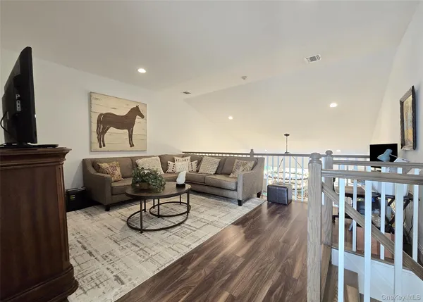 a view of a livingroom with wooden floor and a fireplace