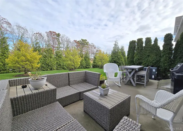 a view of a patio with couches and a table and chairs with wooden floor