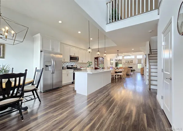 a kitchen with kitchen island granite countertop a sink cabinets and wooden floor
