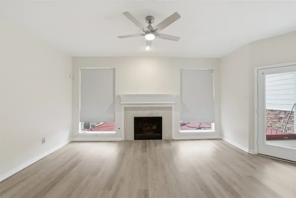 an empty room with fireplace and wooden floor