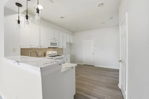 a kitchen with white cabinets and sink