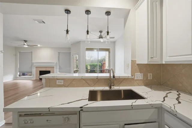 a kitchen with a white cabinets and wooden floor