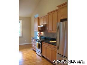 132 Sunny Ridge Road Hendersonville, NC 28739 - Photo 5 of 12 a kitchen with granite countertop a stove and a refrigerator