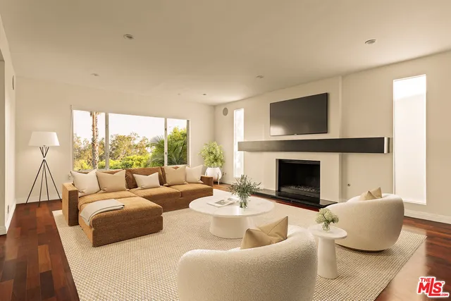 a living room with furniture a fireplace and a large window
