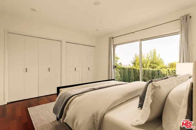 a bedroom with a bed and a large window