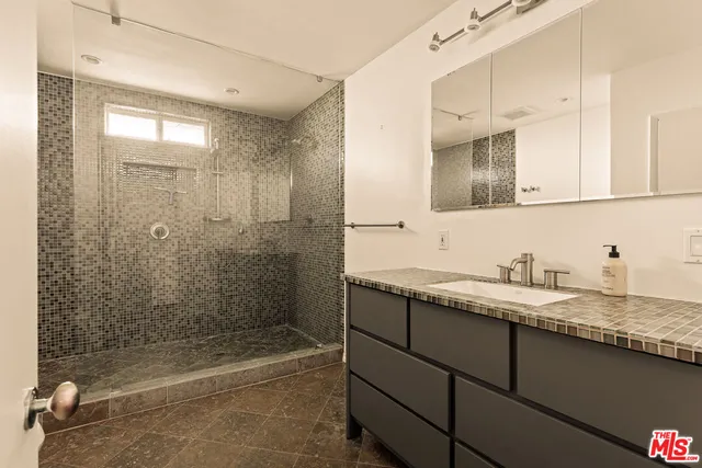 a bathroom with a granite countertop sink mirror and bathtub