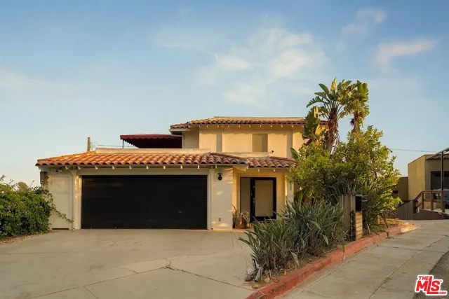 a front view of a house with plants
